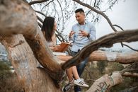 Man in White Shirt Sitting on Tree Branch