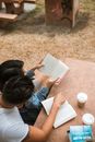 夫妇在野餐桌上喝咖啡，在户外享受安静的阅读时光