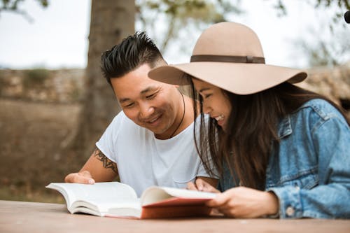 Mulher Com Camisa Branca Com Gola Redonda E Chapéu Fedora Branco Lendo Livro