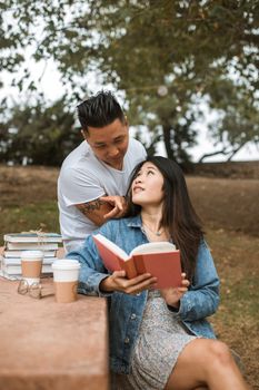 一对亚洲夫妇在宁静的公园里享受轻松的下午阅读时光