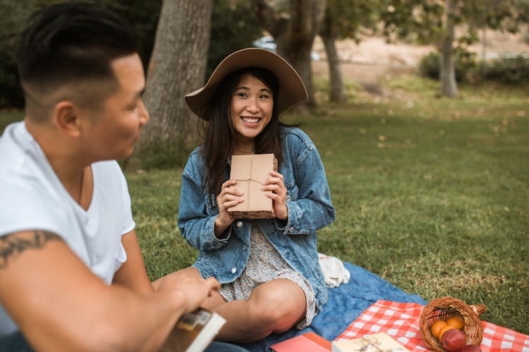 Asian Couple On A Picnic Ground With Books