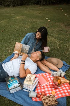 夫妇在阳光明媚的公园里野餐、读书，享受户外的一天