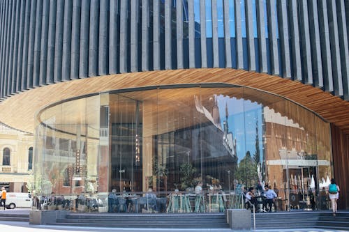 Facade of modern round shaped futuristic building with contemporary restaurant and glass wall with reflection located on street in city