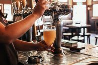 Person Pouring Orange Liquid on Clear Drinking Glass