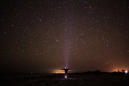 Free Person Standing on Beach Under Starry Night Stock Photo