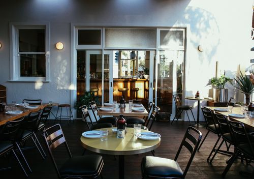 Free Inviting outdoor terrace area with stylish seating and tables in a cozy restaurant setting. Stock Photo