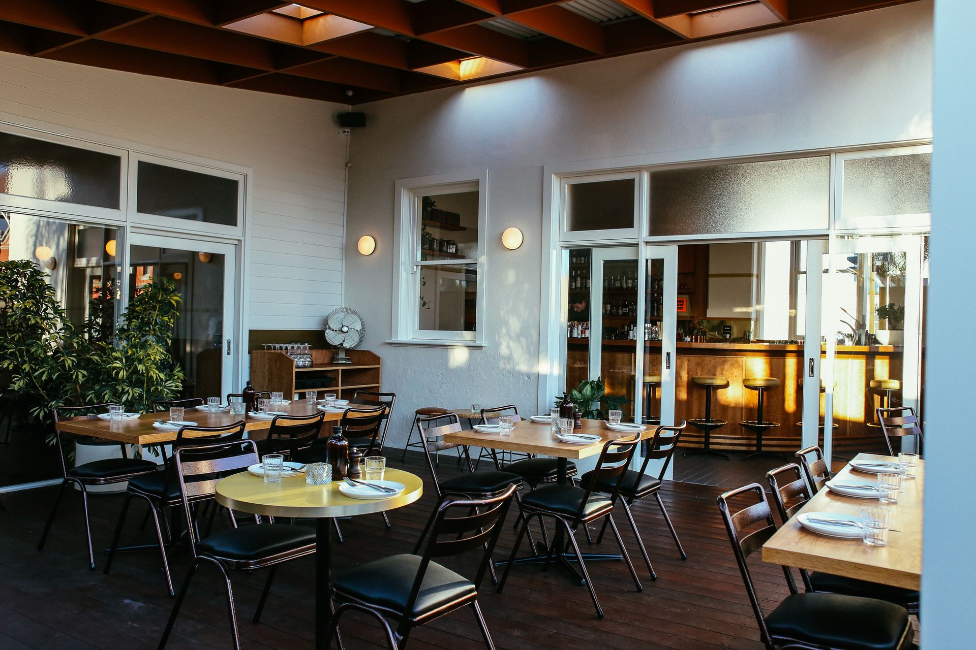 Charming outdoor dining area with tables and chairs set for guests on a restaurant terrace.