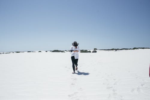 Free Man Walking Through White Sand Stock Photo