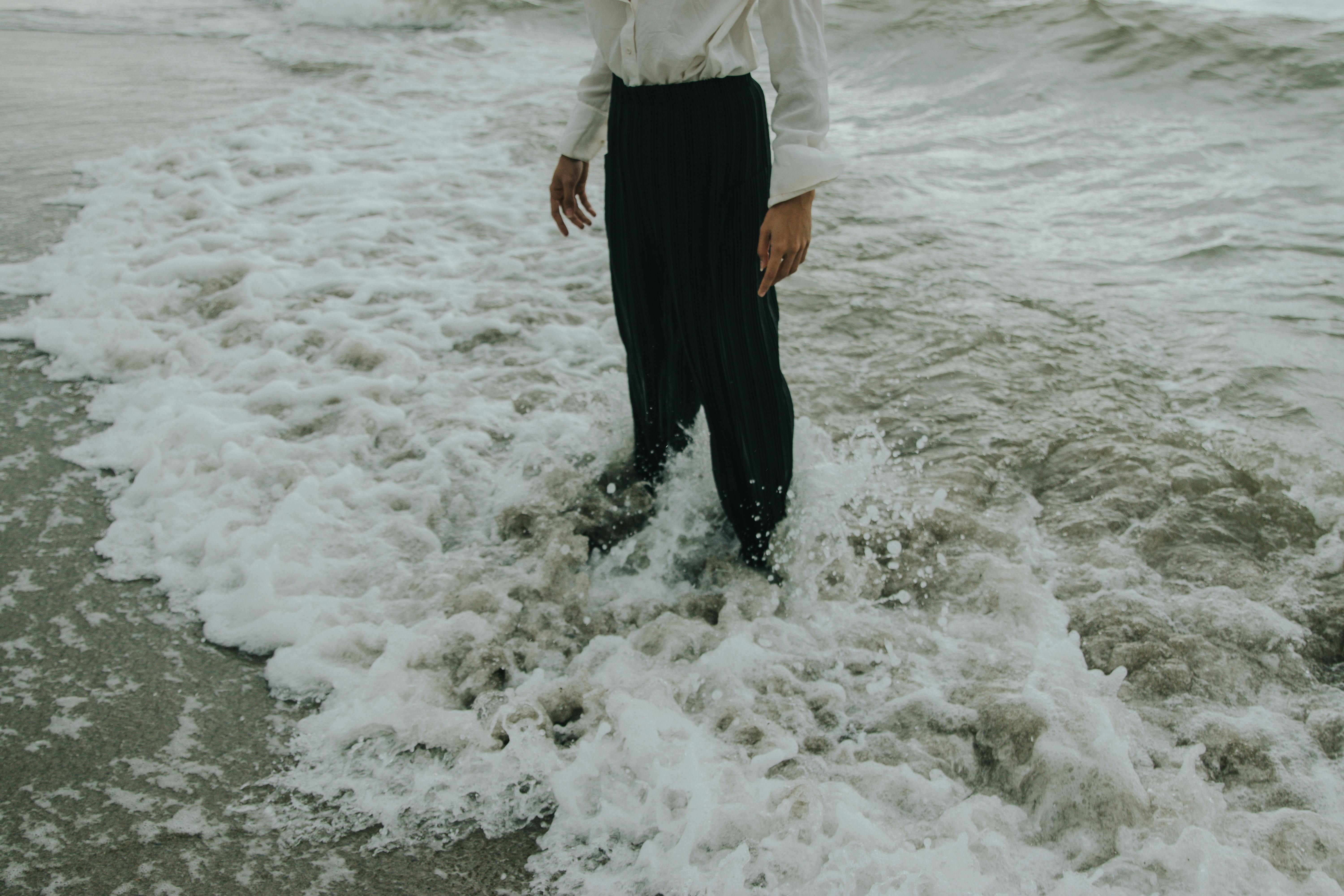 Man with black pants in ocean