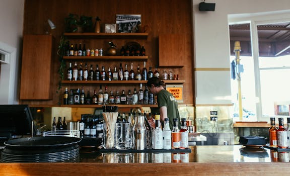 A bartender working behind a well-stocked bar with various bottles and drinks.