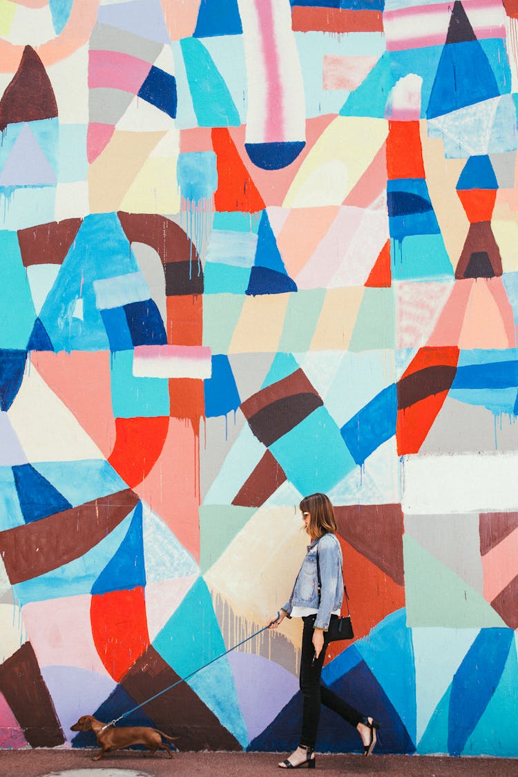 Abstract Mural Behind Woman Walking Dog 