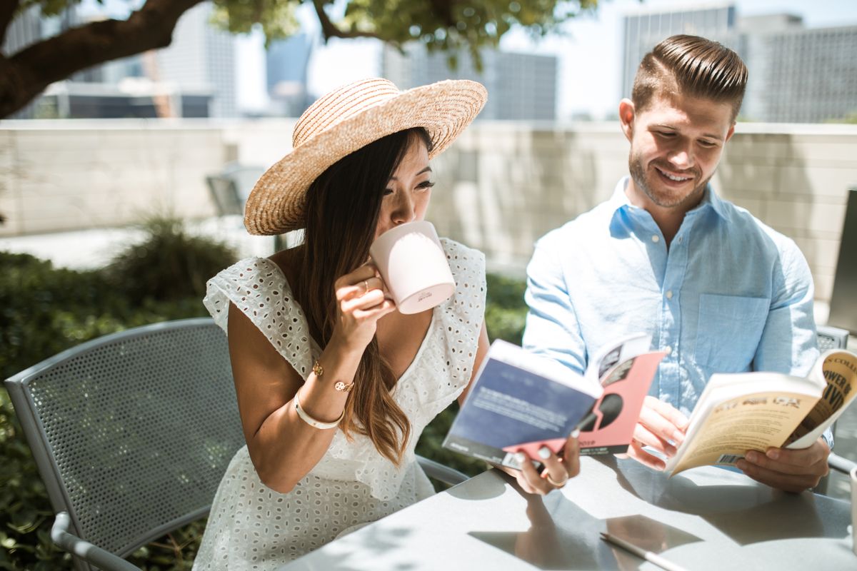Two people reading books side by side