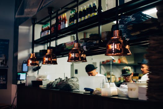 Contemporary restaurant kitchen with staff preparing food under warm lighting.