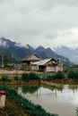 湖边有一座乡村房屋，背景是山脉