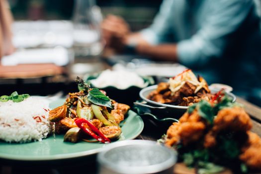 An inviting array of Asian dishes on a wooden table, exuding a cozy dining ambiance.