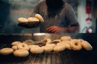 Man in Gray Long Sleeve Shirt Standing Near Donuts