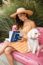 Woman in Pink Dress Holding White Poodle Puppy
