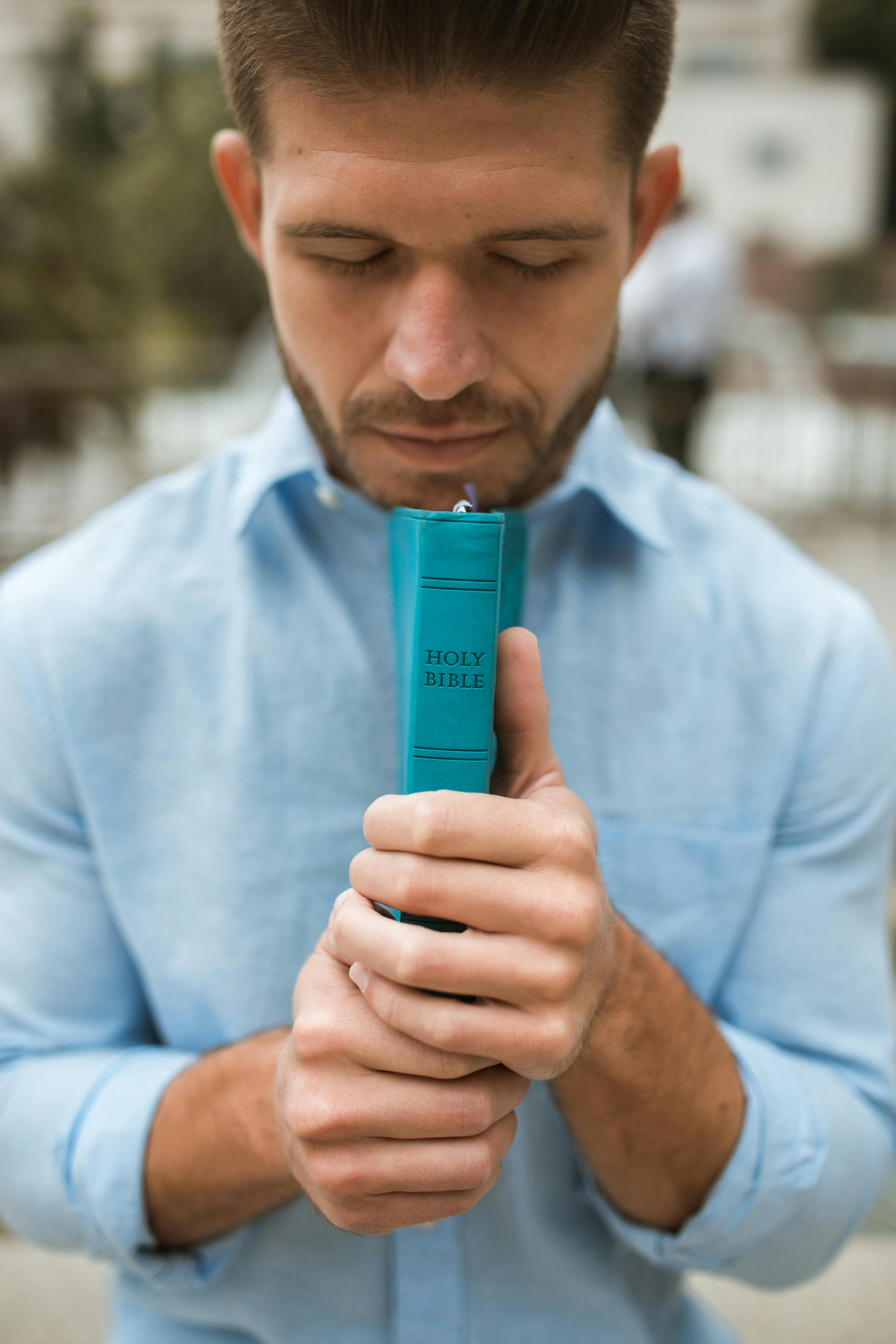 man in blue dress shirt holding blue plastic tube