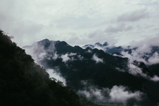 薄雾笼罩的山脉景色壮丽，营造出一种神秘而宁静的气氛