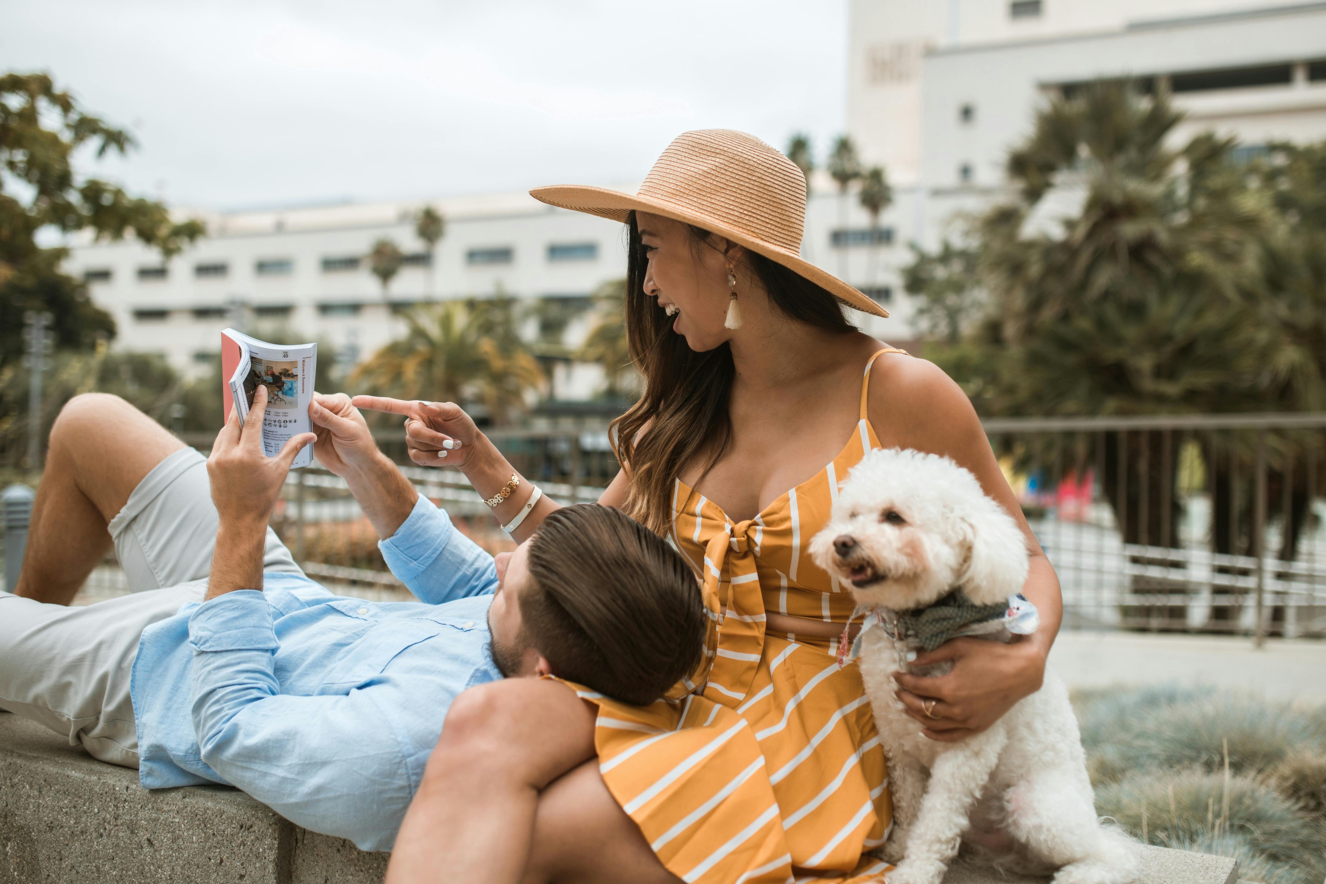 a couple reading book with a dog