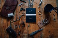 Black and White Box Beside Silver Scissors and Silver Keys on Brown Wooden Table
