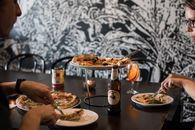 Person Holding White Ceramic Plate With Food on Table