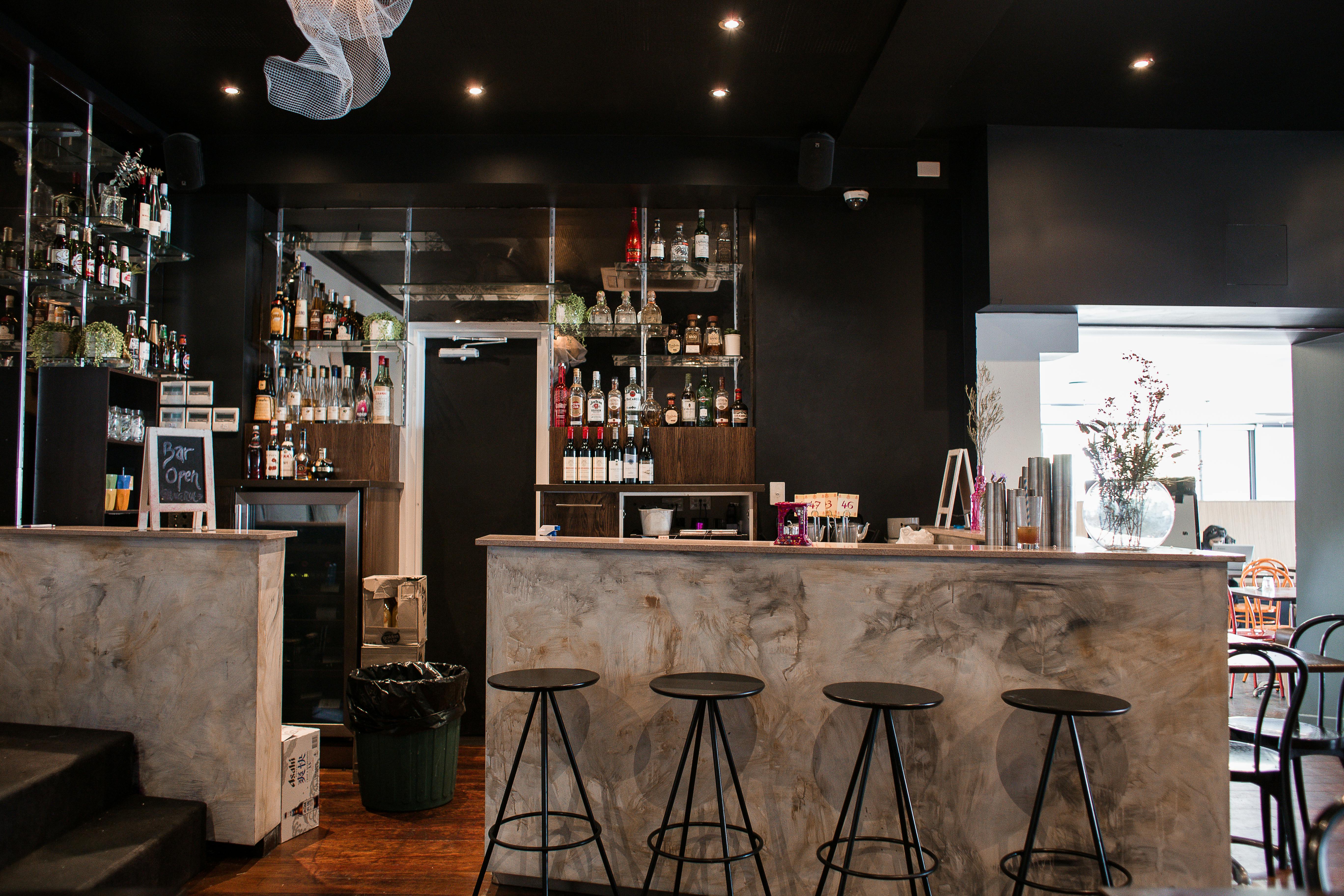 Free Contemporary bar interior featuring a sleek counter and stylish seating in a modern setting. Stock Photo