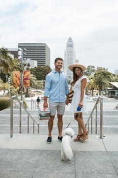 一对异族夫妇在城市公园里牵着狗，享受着一个阳光明媚的日子