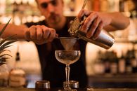 Person Pouring Water on Clear Wine Glass