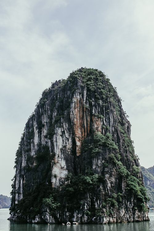 Free Vertical shot of a stunning rock island amidst calm waters, ideal for nature and travel themes. Stock Photo