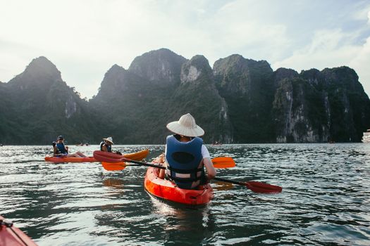 在群山环绕的宁静湖面上，人们划着独木舟，享受冒险的乐趣