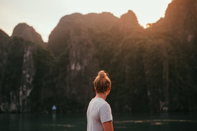 A Person In Gray Shirt Enjoying The Rock Mountain  Magnificent View 