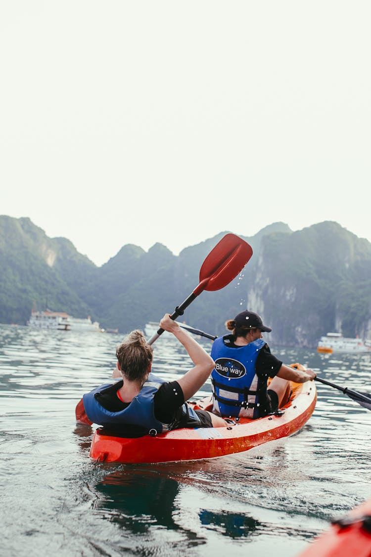  Women Paddling A Kayak In Tandem