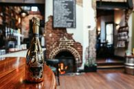 Brown Glass Bottle on Brown Wooden Table