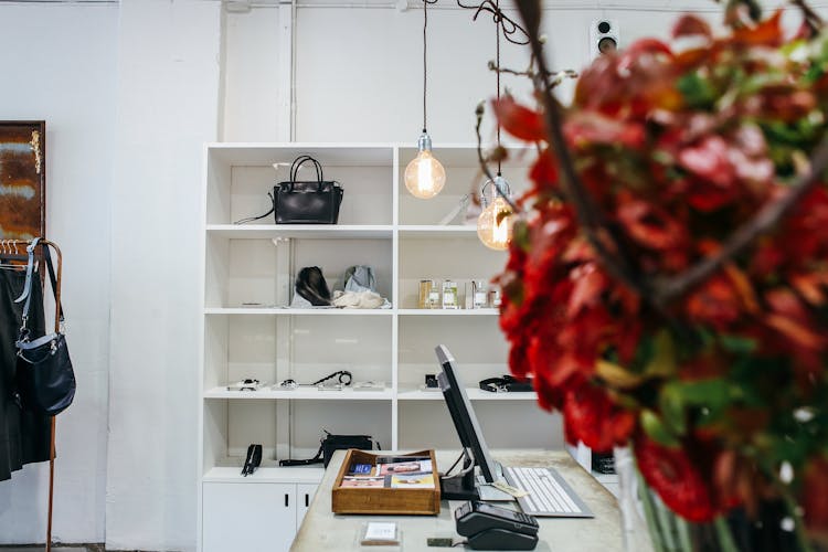 Bags And Perfume Bottles On White Wooden Display Shelves 