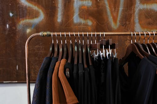 Black and Brown Clothes Hanging on Metal Clothes Rack 