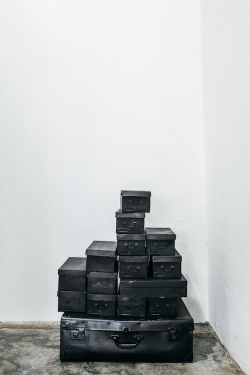 Stacks of Black Boxes on Black Suitcase 