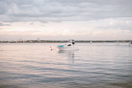 一艘游艇停泊在平静的水面上，天空多云