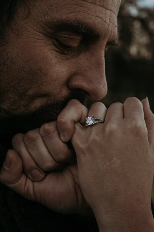 Man Kissing a Hand With an Engagement Ring