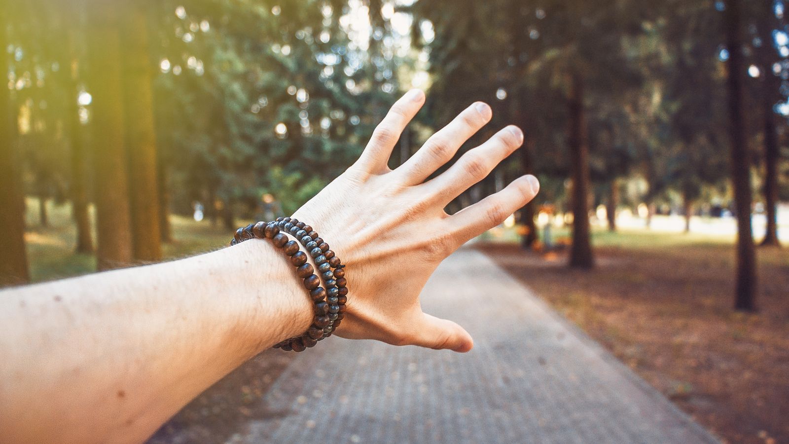 Person resting a wrapped wrist outdoors in bright daylight