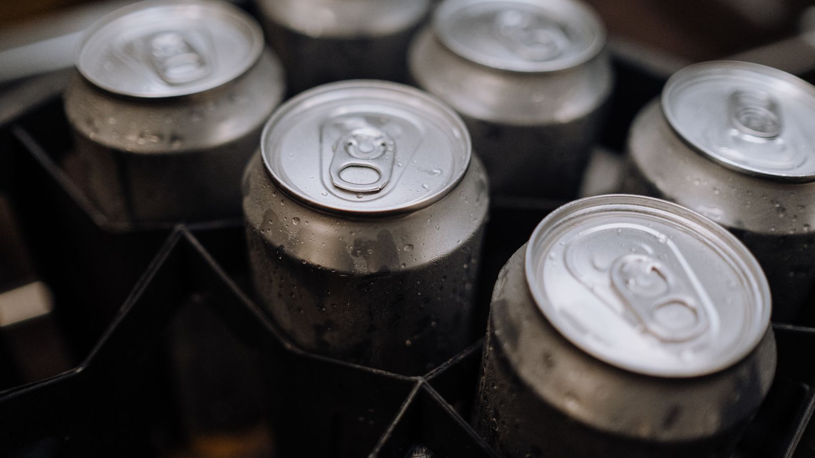 Detailed view of aluminum cans with condensation, perfect for industrial and brewery themes.