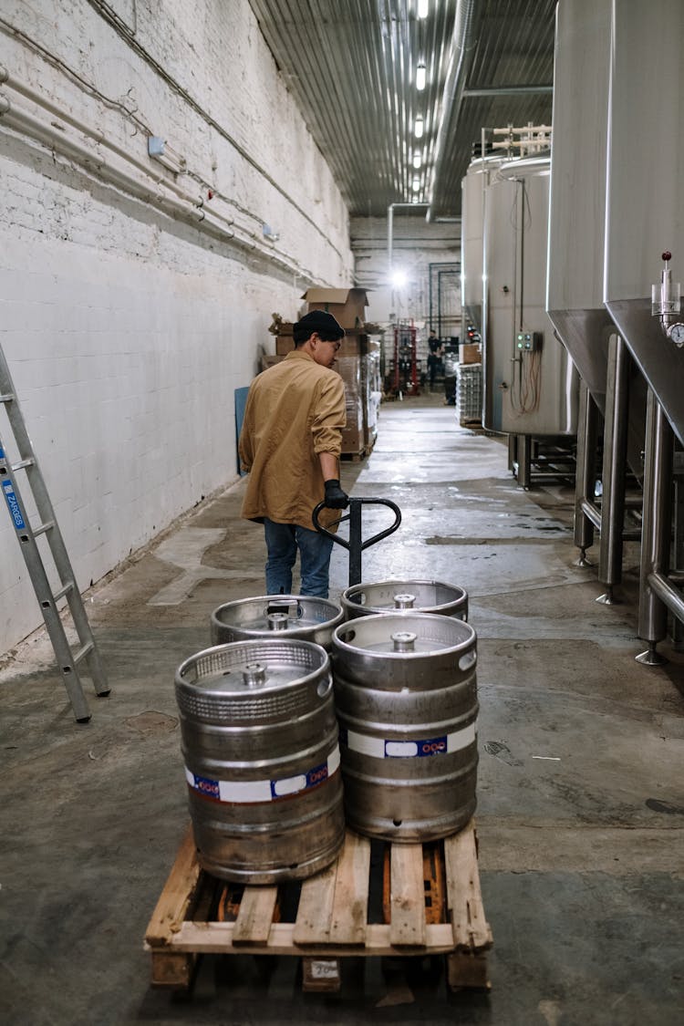 A Man Pulling A Cart With Canisters