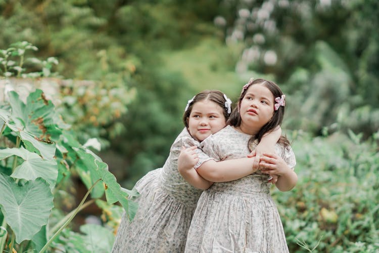 Embracing Sisters In Garden