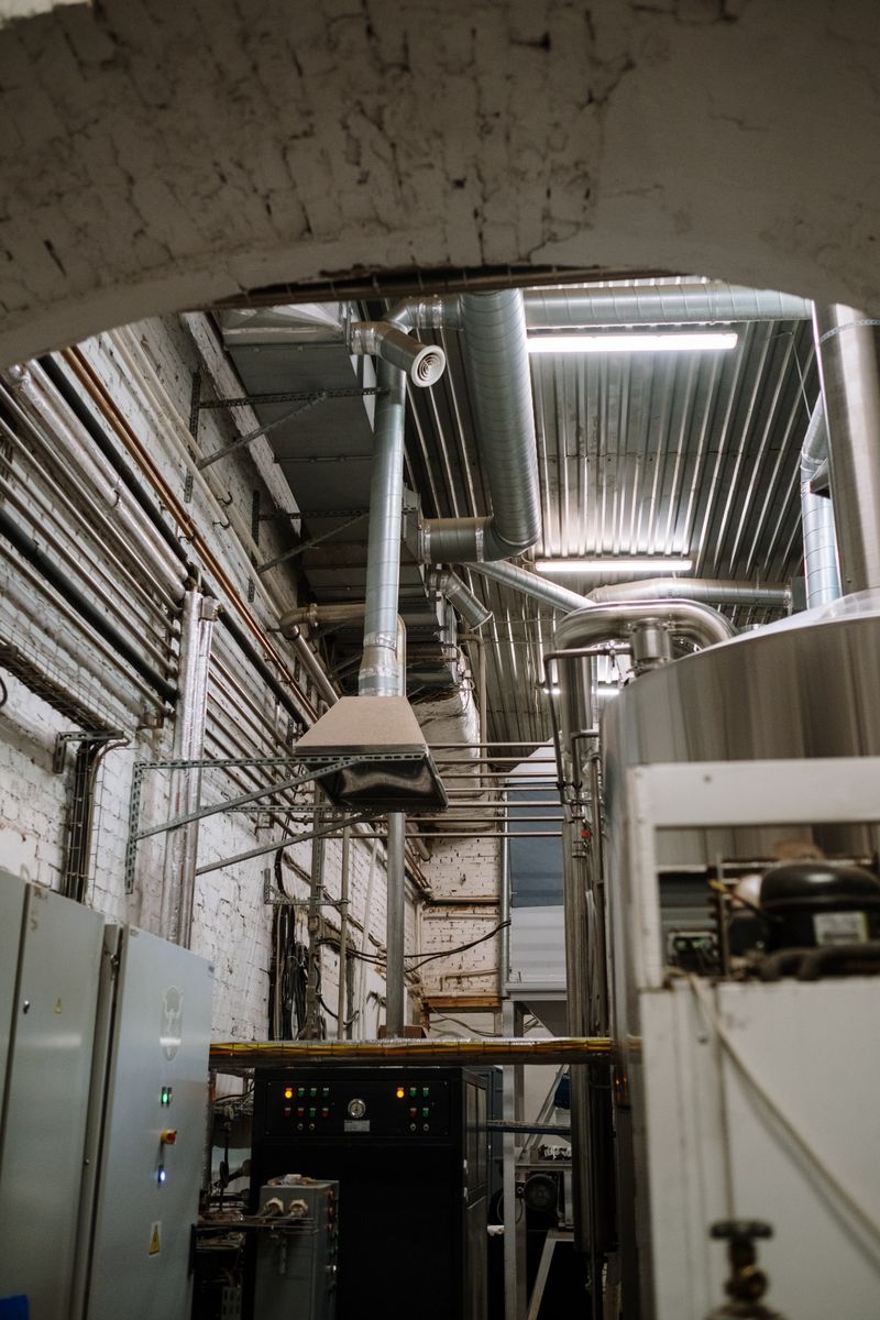 Stainless steel equipment inside a modern industrial facility with piping