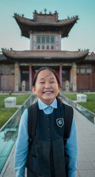 一位开朗的年轻学生在亚洲传统建筑前灿烂微笑，画面极具教育意义