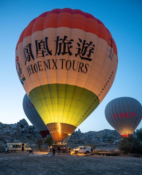 Free Lit hot air balloons ready for flight at dawn in Cappadocia's unique landscape. Stock Photo
