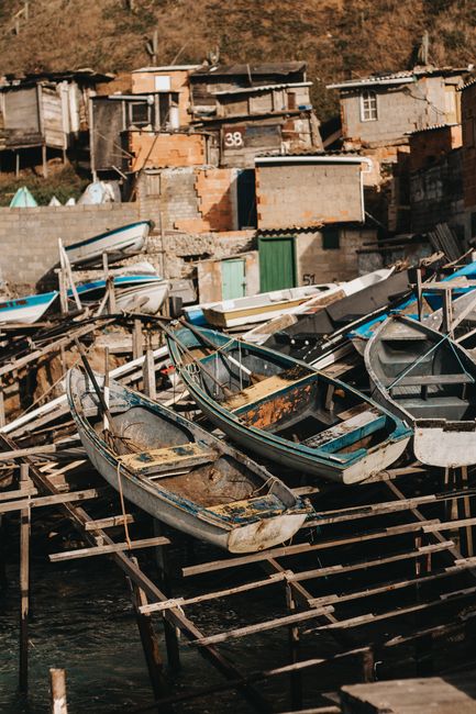 Old boats and makeshift shacks in Arraial do Cabo, Brazil, depicting a rustic coastal village scene. — Cova do Vapor, Portugal.