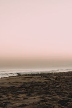 Peaceful sunset over Saquarema beach with gentle waves and sandy shore.