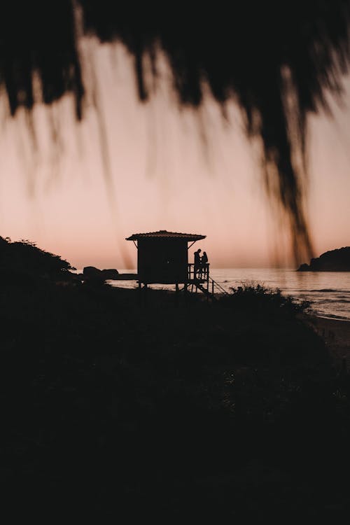 Silhouette of People at a Lifeguard's Tower