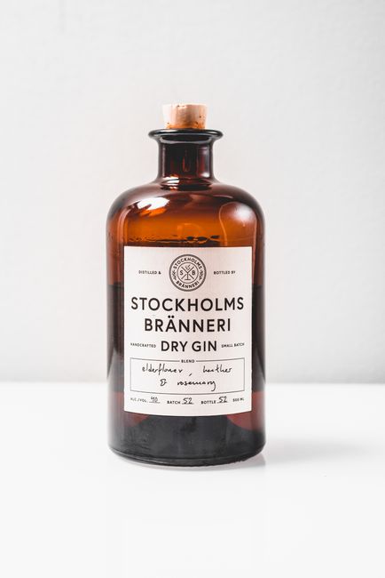 Brown glass bottle of Stockholms Bränneri Dry Gin on a white background.
